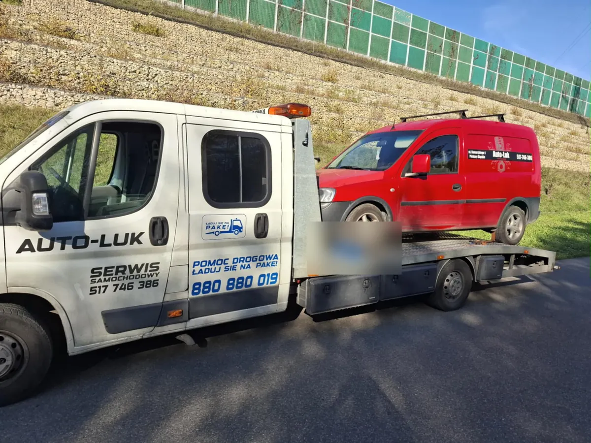 Czerwony Opel Combo na lawecie przy ekranach akustycznych i gabionach autostrady