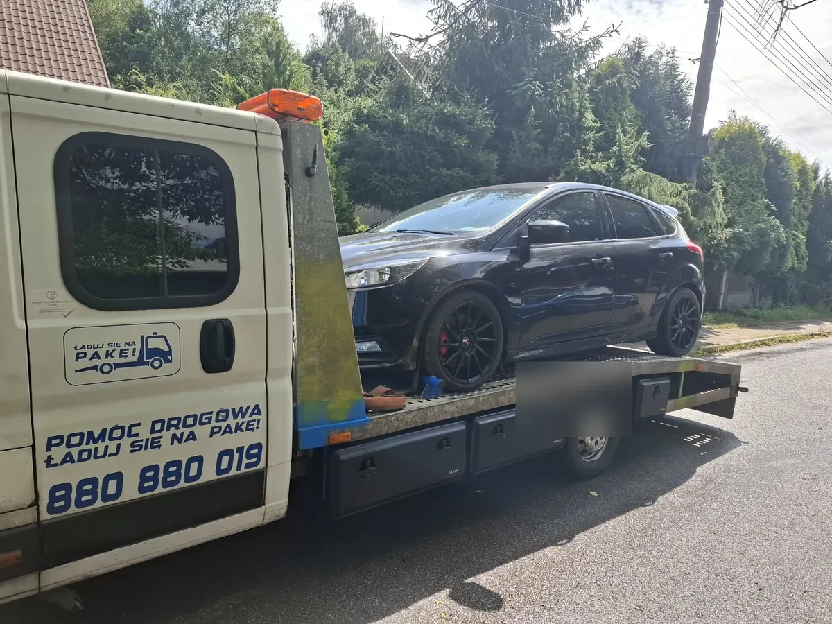 Czarny Ford Focus na lawecie, widok od tyłu kabiny
