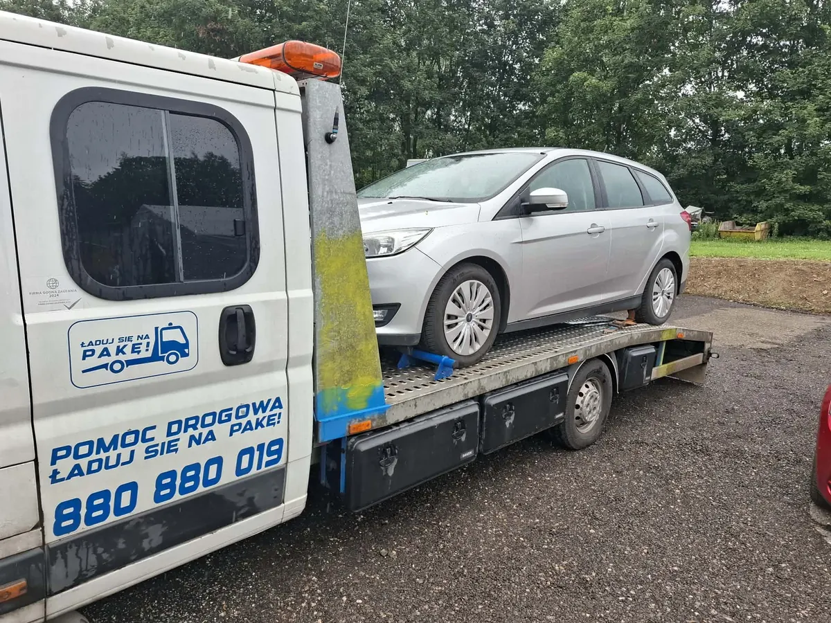 Srebrny Ford Focus kombi na platformie lawety