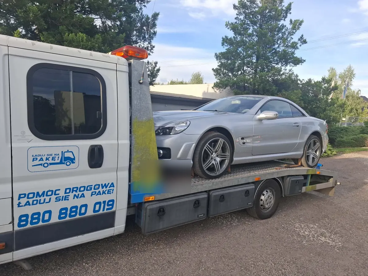 Srebrny Mercedes SL na lawecie na parkingu przy restauracji