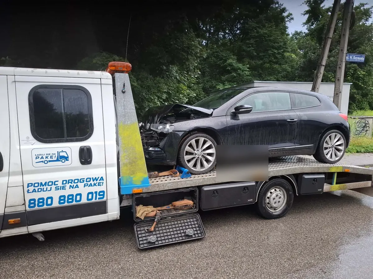 Czarny VW Scirocco z uszkodzonym przodem na lawecie